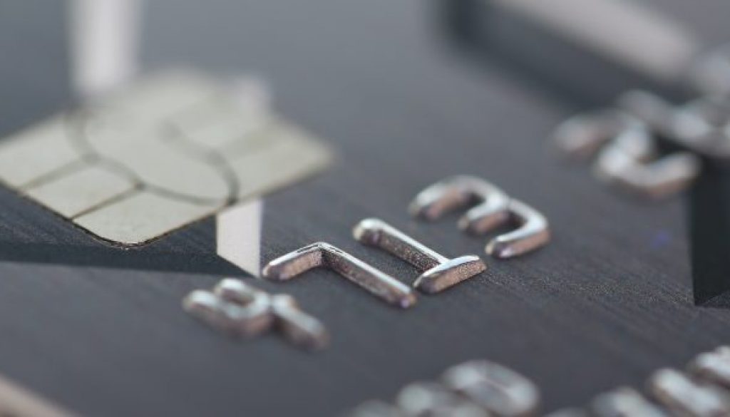 Embossed chipped credit card lying on silver keyboard
