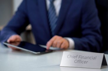 Male chief financial officer planning company budget on tablet pc, office work