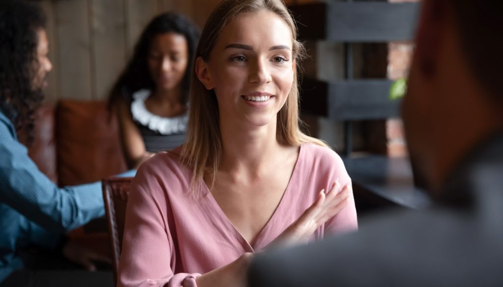 Woman participating in speed dating chatting with guy in cafe