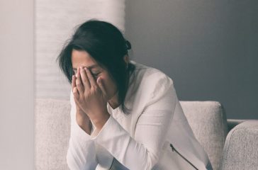 Coronavirus COVID-19 impact on retail businesses shut down causing unemployment financial distress. Depressed crying business woman stressed with headache.
