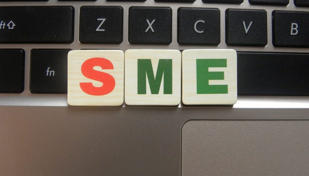 Abbreviation SME (Small and Medium sized Enterprise) on keyboard background