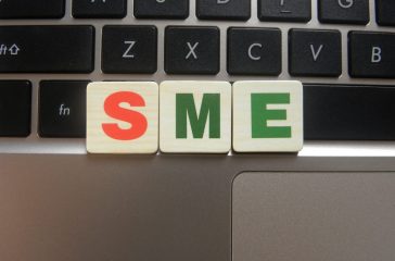 Abbreviation SME (Small and Medium sized Enterprise) on keyboard background