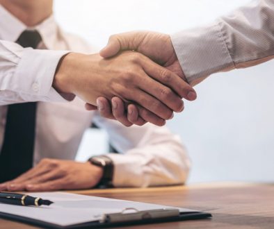 Estate broker agent and customer shaking hands after signing contract documents for realty purchase mortgage loan approval