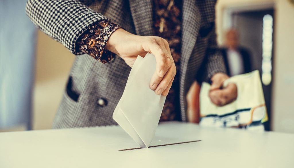 Person casting a ballot at a polling station