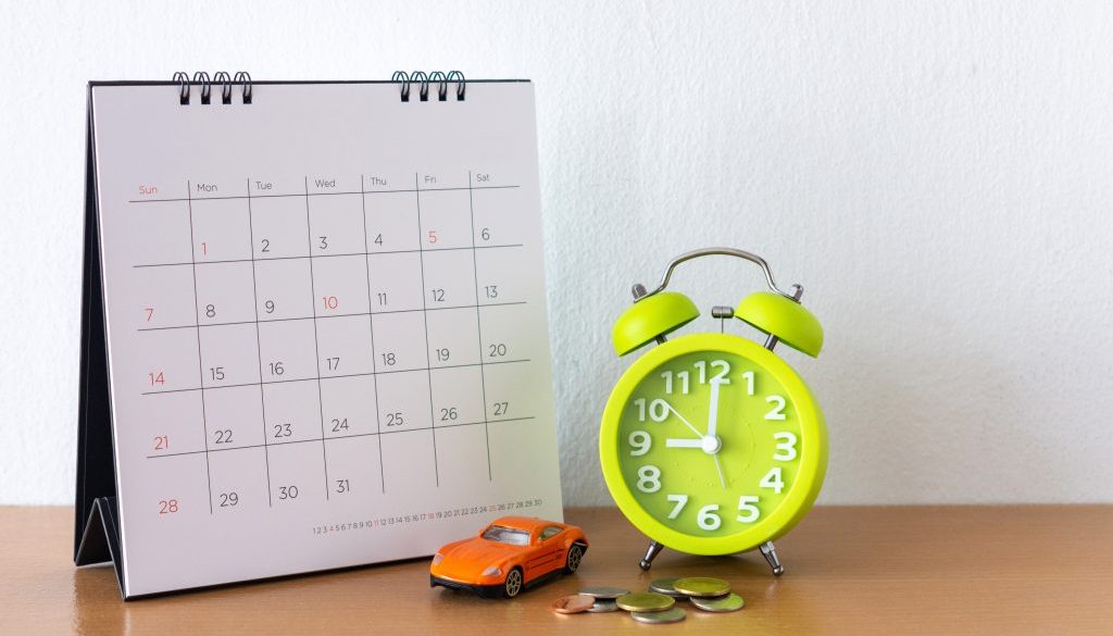 Calendar and car on table. Day of buying or selling a car or payment for rent or loan or repair