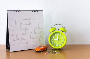 Calendar and car on table. Day of buying or selling a car or payment for rent or loan or repair