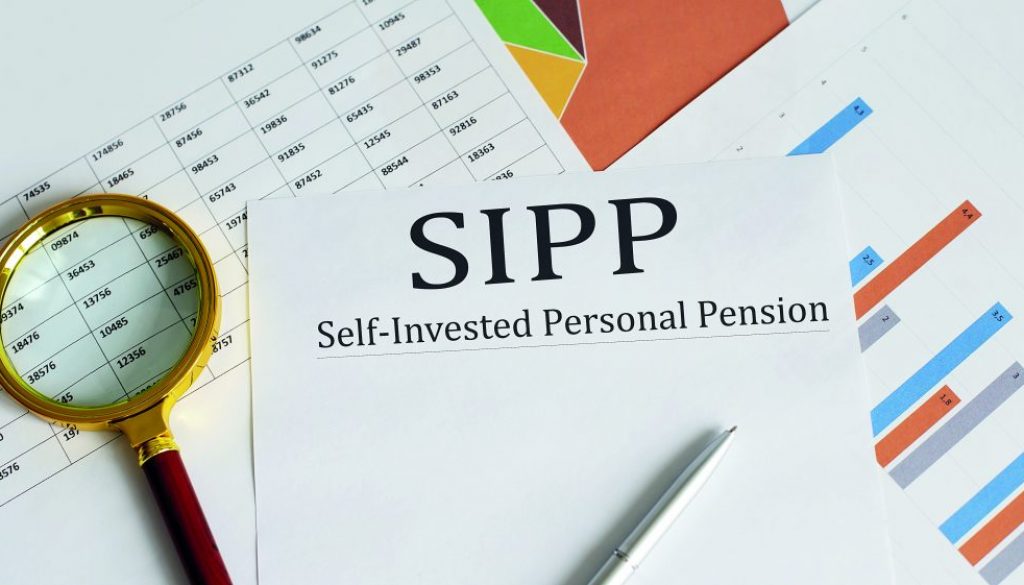 Paper with Self-Invested Personal Pension SIPP on a table with chart, pen and magnifier