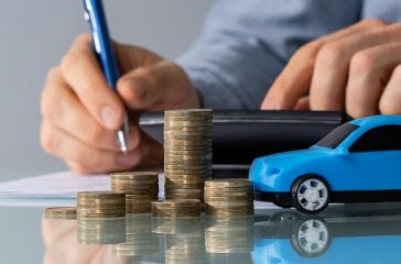 Toy Car In Front Of Businessman Calculating Loan