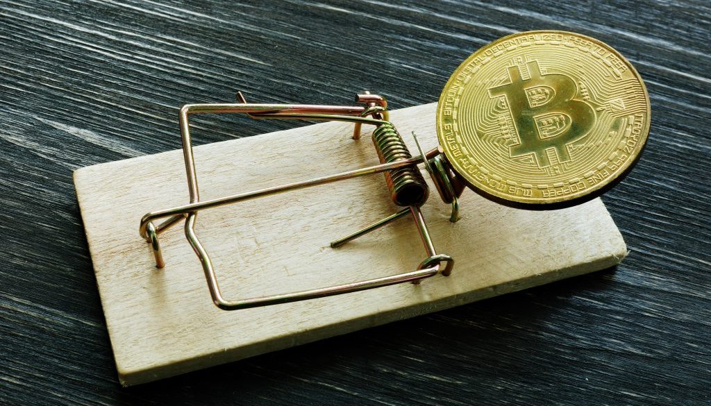 Mousetrap and bitcoin coin. Cryptocurrency scam or fraud concept.