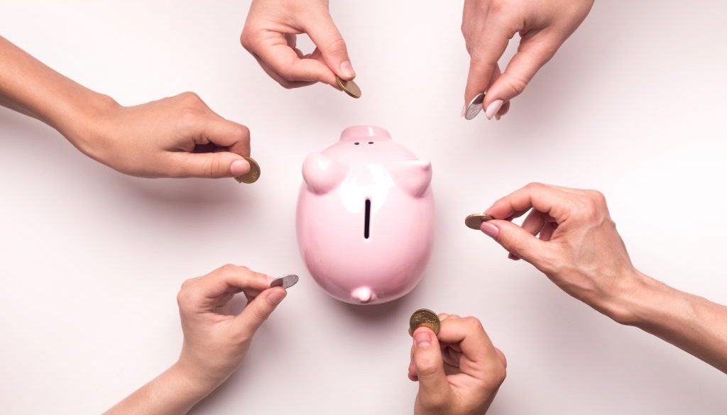 People hands throwing coins in piggy bank for crowdfunding